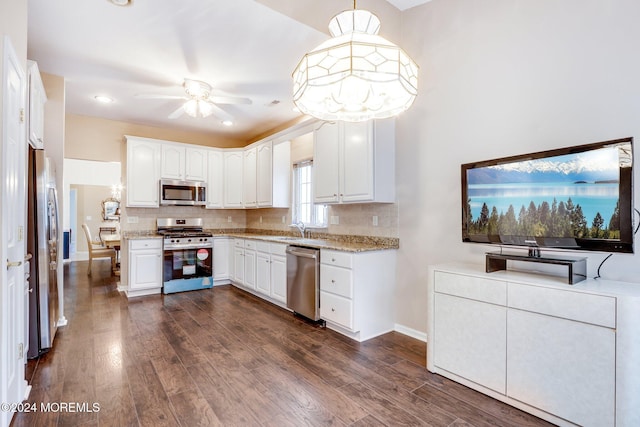 kitchen featuring white cabinetry, sink, hanging light fixtures, dark hardwood / wood-style floors, and appliances with stainless steel finishes