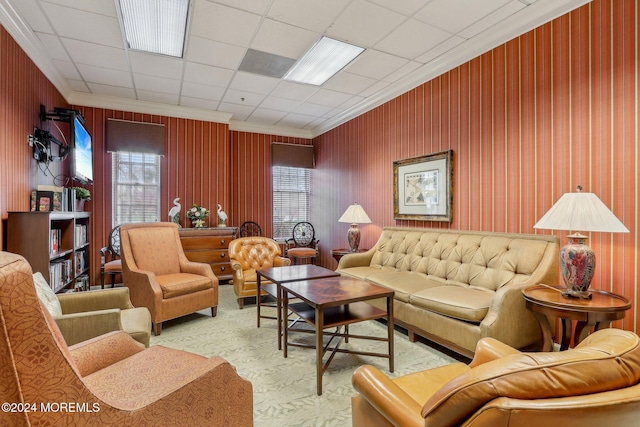 living room with carpet, a drop ceiling, and crown molding