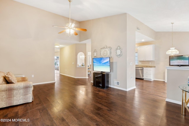 unfurnished living room with high vaulted ceiling, dark hardwood / wood-style floors, plenty of natural light, and ceiling fan