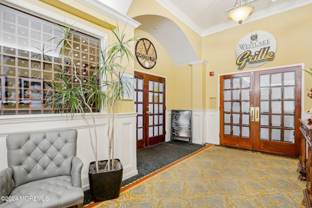 entryway featuring french doors, carpet floors, crown molding, and a high ceiling