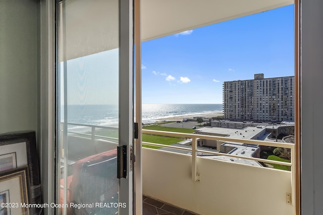 balcony featuring a view of the beach and a water view