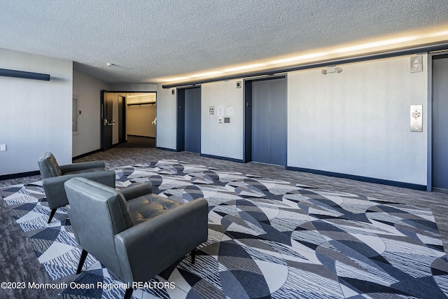 carpeted cinema featuring elevator and a textured ceiling