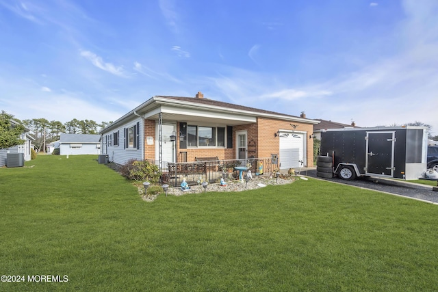 rear view of house with covered porch, a garage, central AC unit, and a lawn