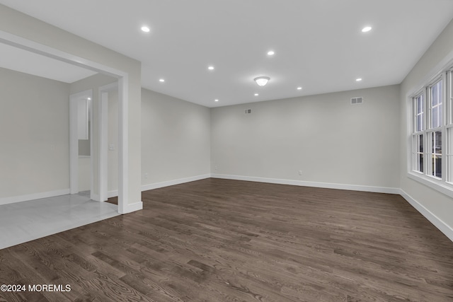 unfurnished room with dark wood-type flooring