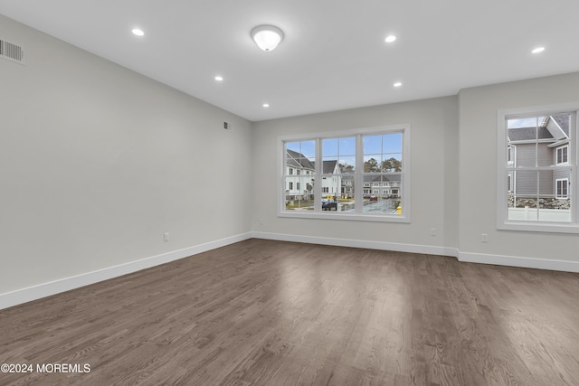 spare room featuring a wealth of natural light and hardwood / wood-style floors