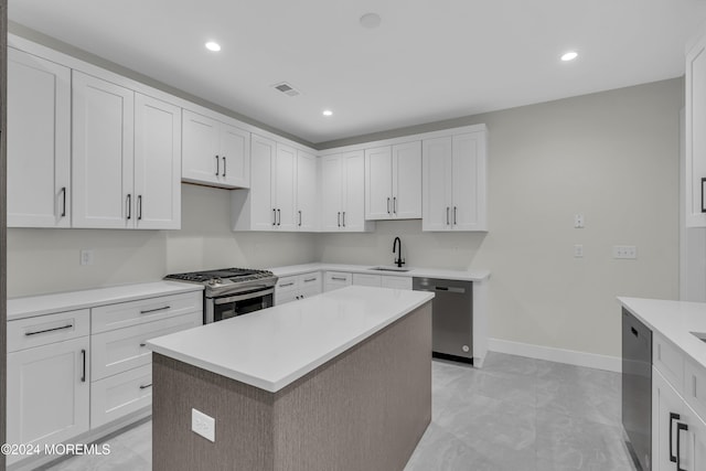 kitchen with sink, white cabinets, stainless steel appliances, and a kitchen island