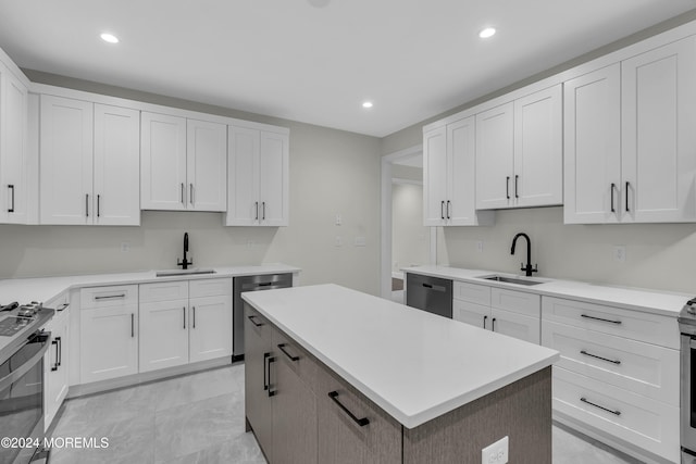 kitchen with white cabinetry, sink, a center island, and stainless steel appliances