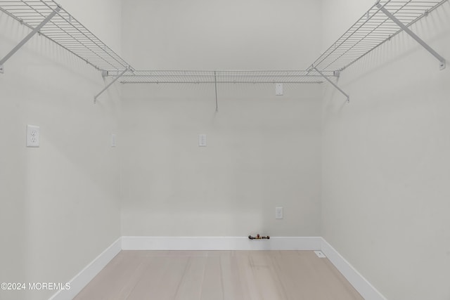 walk in closet with hardwood / wood-style floors