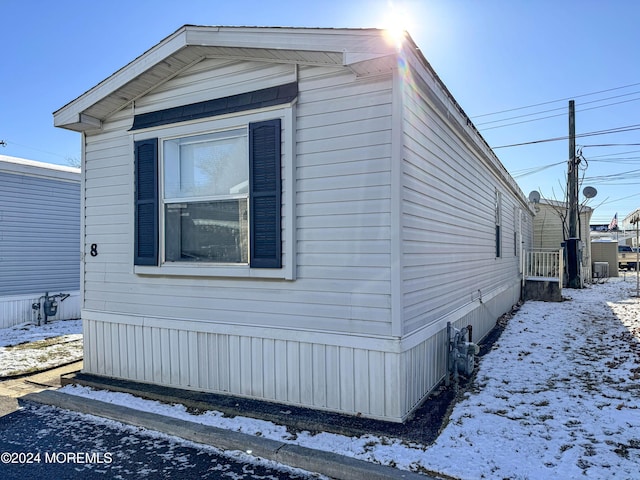 view of snowy exterior with central AC unit