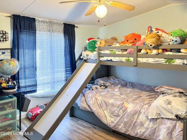 bedroom featuring ceiling fan, wood-type flooring, and ornamental molding