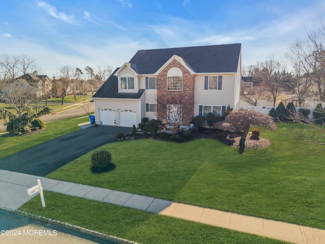 view of front of house with a front yard and a garage