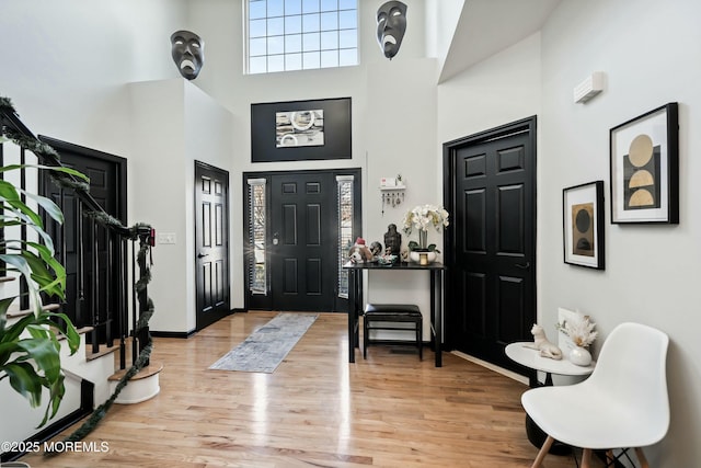 entryway with a towering ceiling and light hardwood / wood-style floors