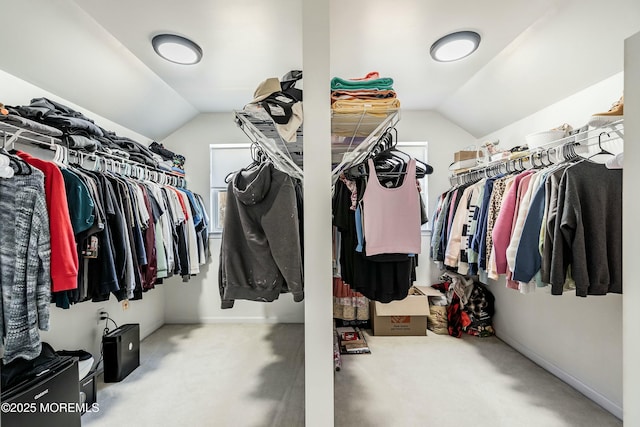 walk in closet featuring carpet flooring and lofted ceiling