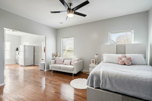 bedroom featuring ceiling fan, hardwood / wood-style floors, and white fridge