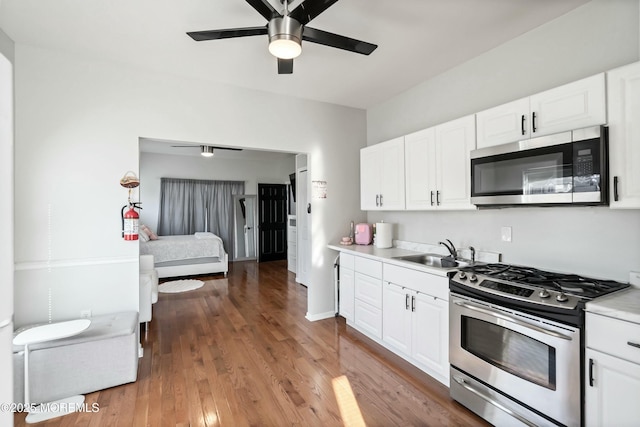 kitchen featuring hardwood / wood-style flooring, white cabinetry, and stainless steel appliances