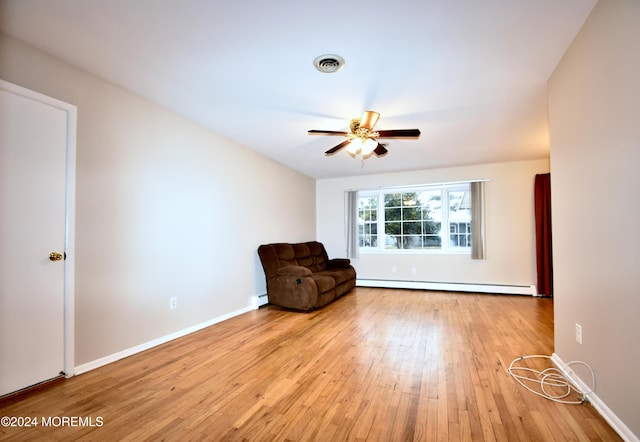 unfurnished room with ceiling fan, light hardwood / wood-style flooring, and a baseboard heating unit