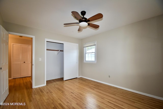 unfurnished bedroom featuring ceiling fan, light hardwood / wood-style floors, and a closet