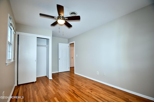 unfurnished bedroom with light wood-type flooring, a closet, and ceiling fan