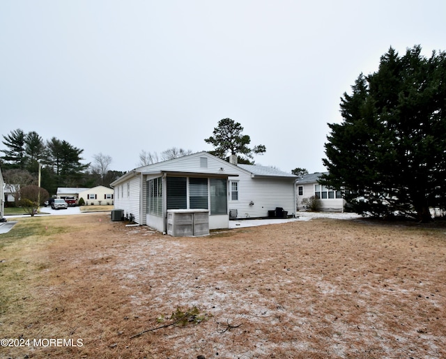 view of front of home featuring a sunroom and central AC unit