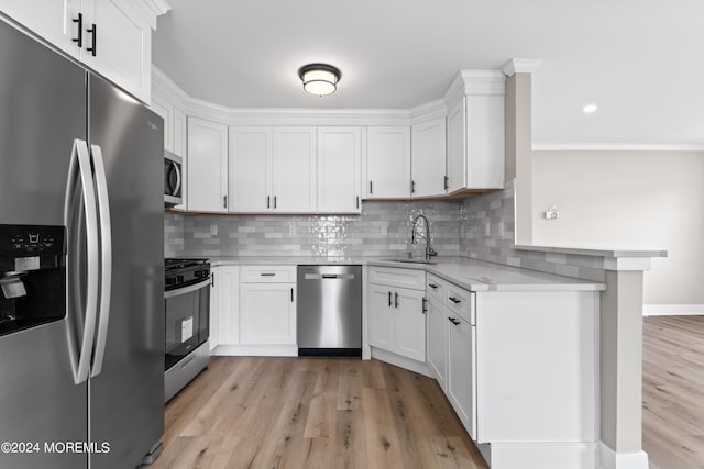 kitchen with white cabinets, stainless steel appliances, and light hardwood / wood-style flooring