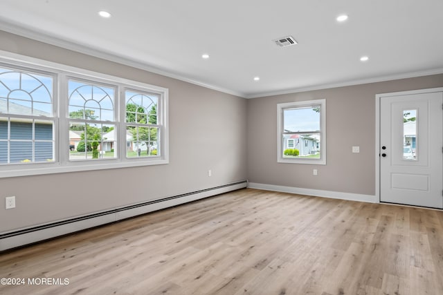 foyer entrance featuring baseboard heating, a wealth of natural light, light hardwood / wood-style floors, and ornamental molding