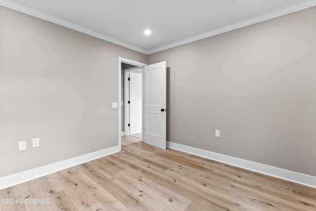 spare room with light hardwood / wood-style flooring and crown molding