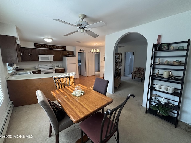 dining room featuring sink, a baseboard radiator, and ceiling fan with notable chandelier