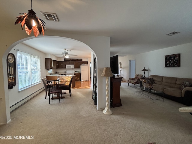 carpeted dining space with ceiling fan and a baseboard radiator