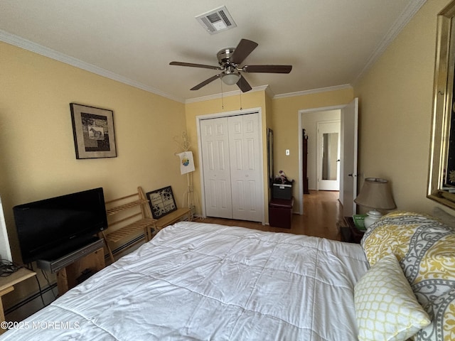 bedroom featuring hardwood / wood-style floors, a baseboard heating unit, ceiling fan, ornamental molding, and a closet