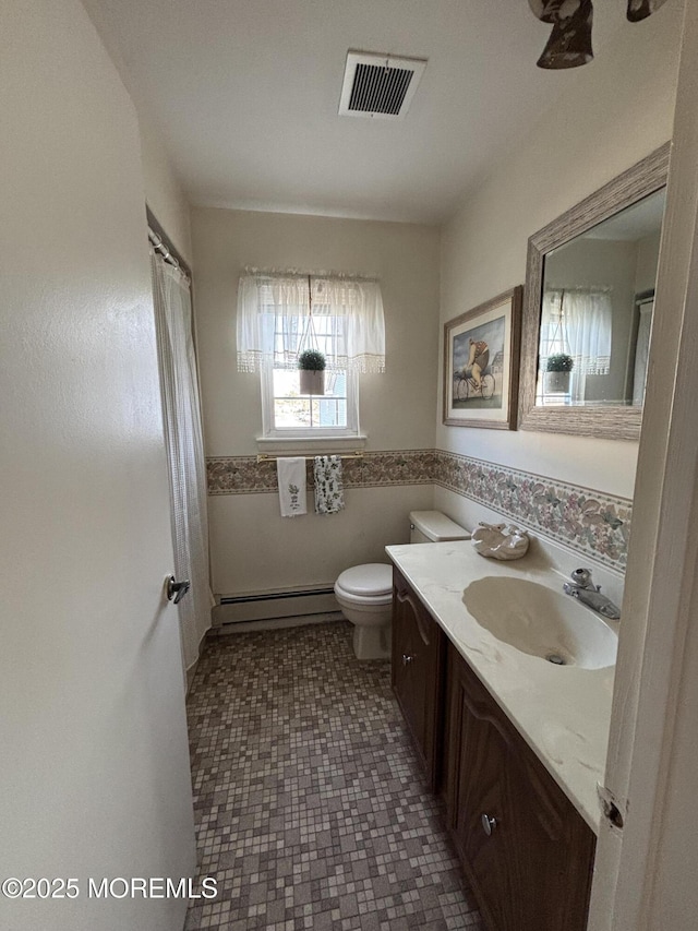 bathroom featuring vanity, toilet, and baseboard heating