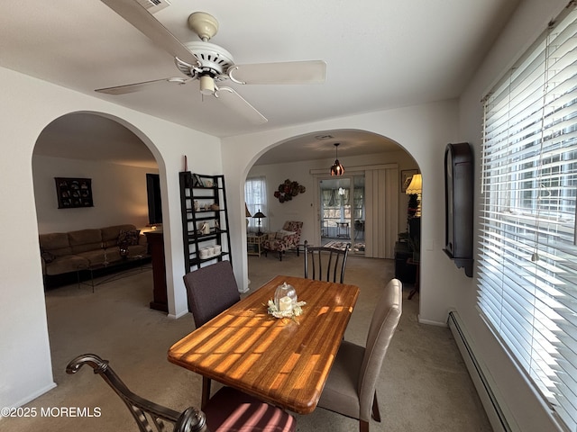 carpeted dining area with a baseboard radiator and ceiling fan