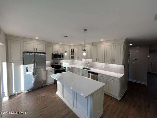 kitchen with white cabinetry, a center island, hanging light fixtures, dark wood-type flooring, and appliances with stainless steel finishes