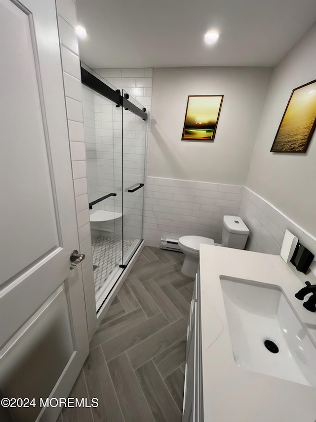 bathroom featuring a shower with door, toilet, and tile walls