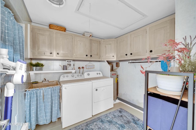 washroom with cabinets, washer and clothes dryer, and water heater