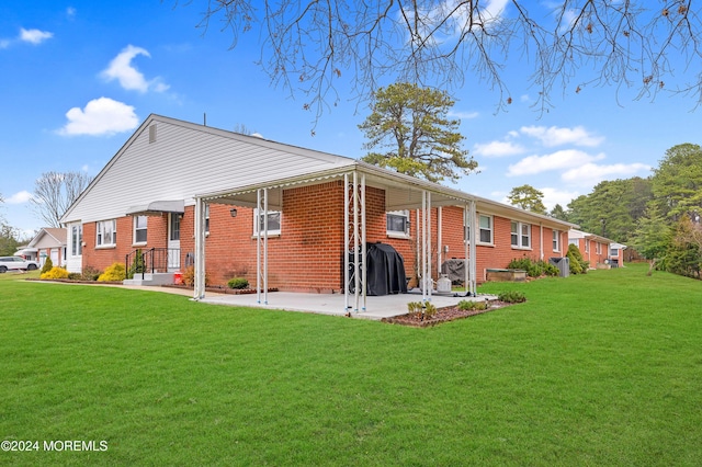 back of house featuring a lawn and a patio area