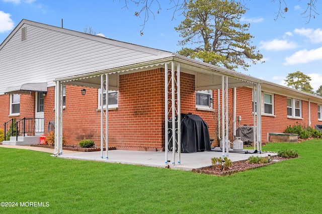 rear view of house with a yard and a patio