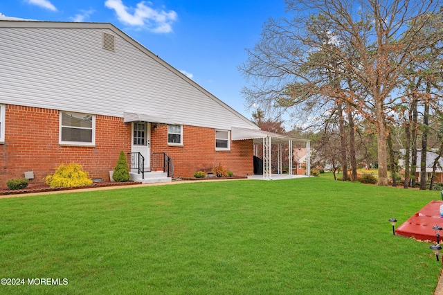 back of property featuring a lawn and a patio area