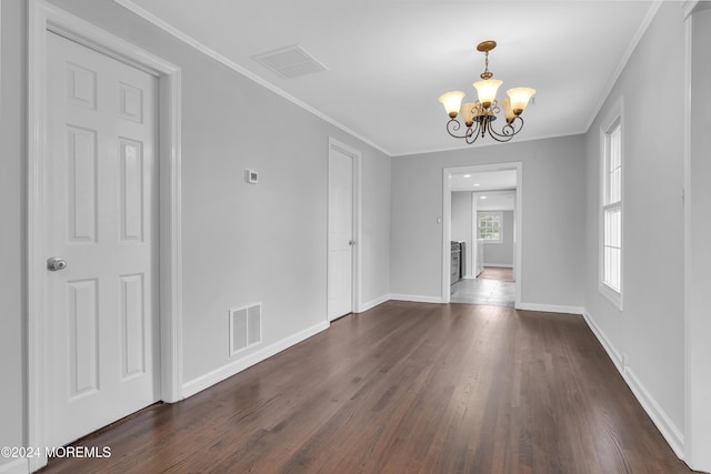 unfurnished room featuring crown molding, dark wood-type flooring, and a chandelier