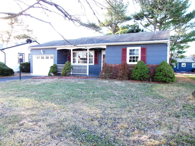 ranch-style home featuring a porch, a garage, and a front yard