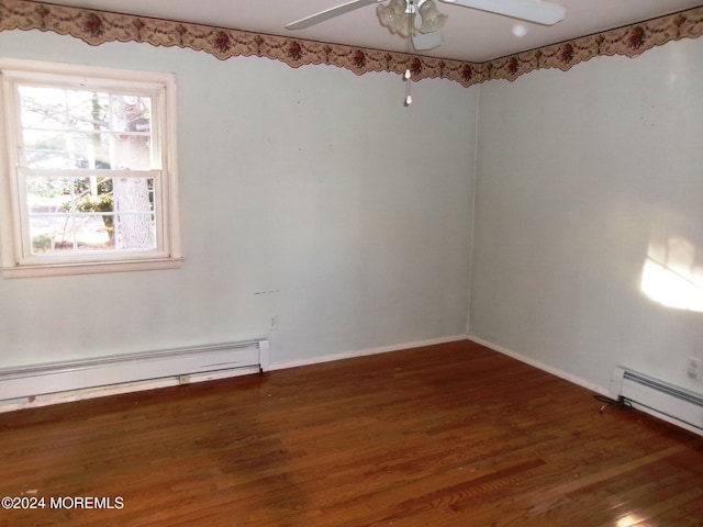 empty room featuring dark hardwood / wood-style flooring, baseboard heating, and ceiling fan