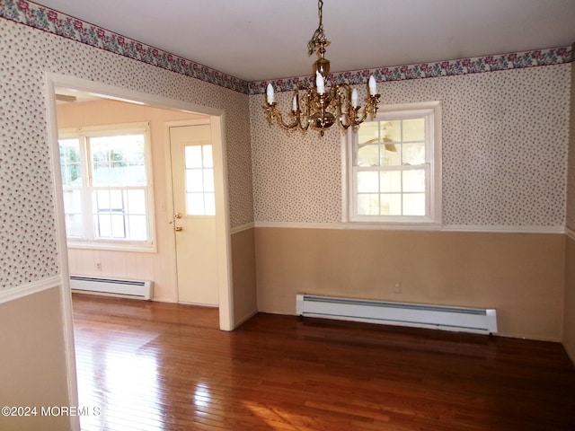 unfurnished dining area featuring hardwood / wood-style floors, a baseboard radiator, and a notable chandelier