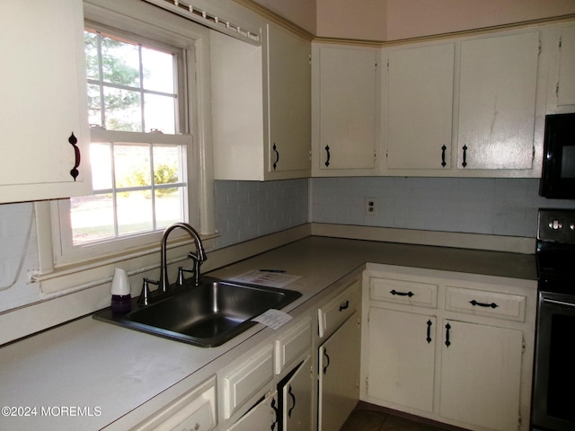 kitchen featuring decorative backsplash, white cabinetry, black appliances, and sink