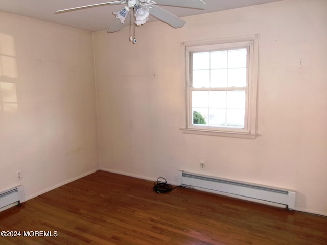 empty room featuring baseboard heating, ceiling fan, and dark wood-type flooring