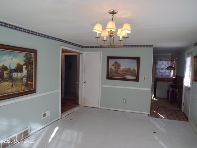 unfurnished dining area featuring concrete floors and a chandelier