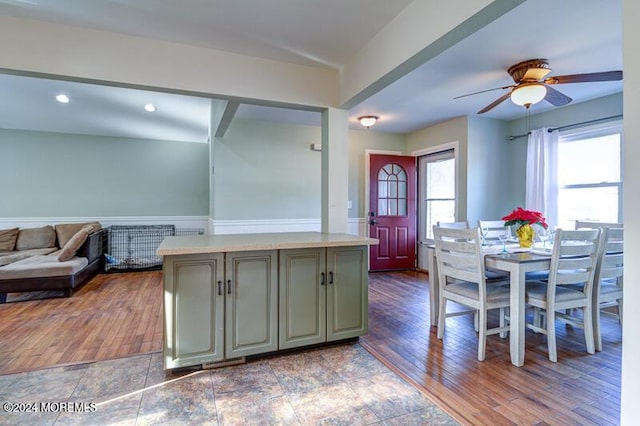 kitchen with hardwood / wood-style flooring, ceiling fan, and a center island