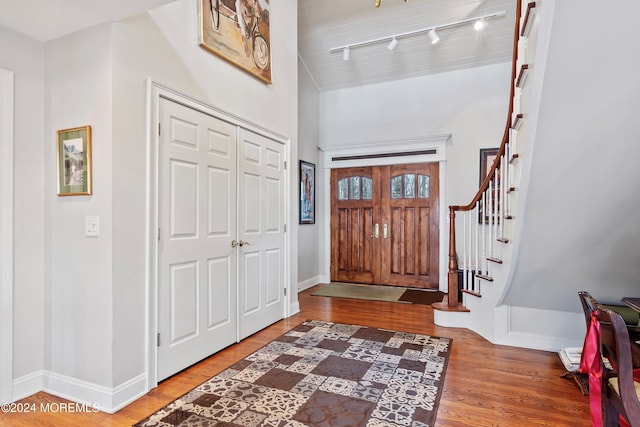 foyer with hardwood / wood-style floors and rail lighting