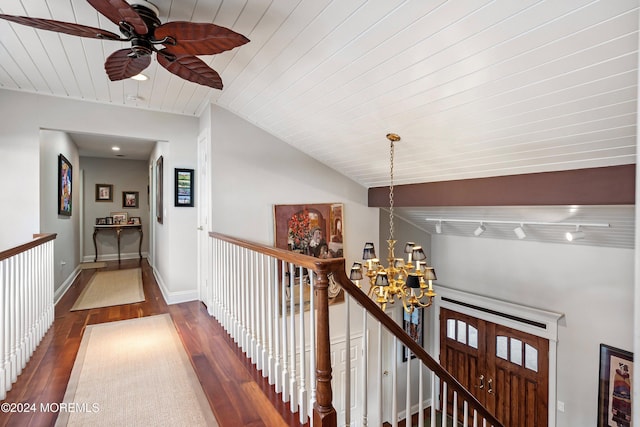 corridor featuring a chandelier, dark hardwood / wood-style flooring, wooden ceiling, and vaulted ceiling