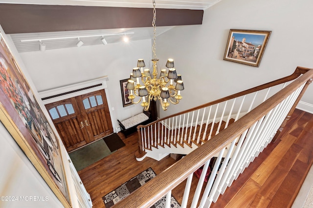 stairs featuring a chandelier and hardwood / wood-style floors