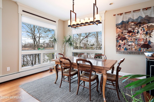 dining area featuring wood-type flooring and a baseboard heating unit