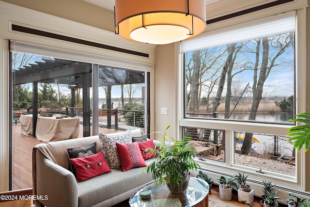 sunroom featuring a water view and a healthy amount of sunlight